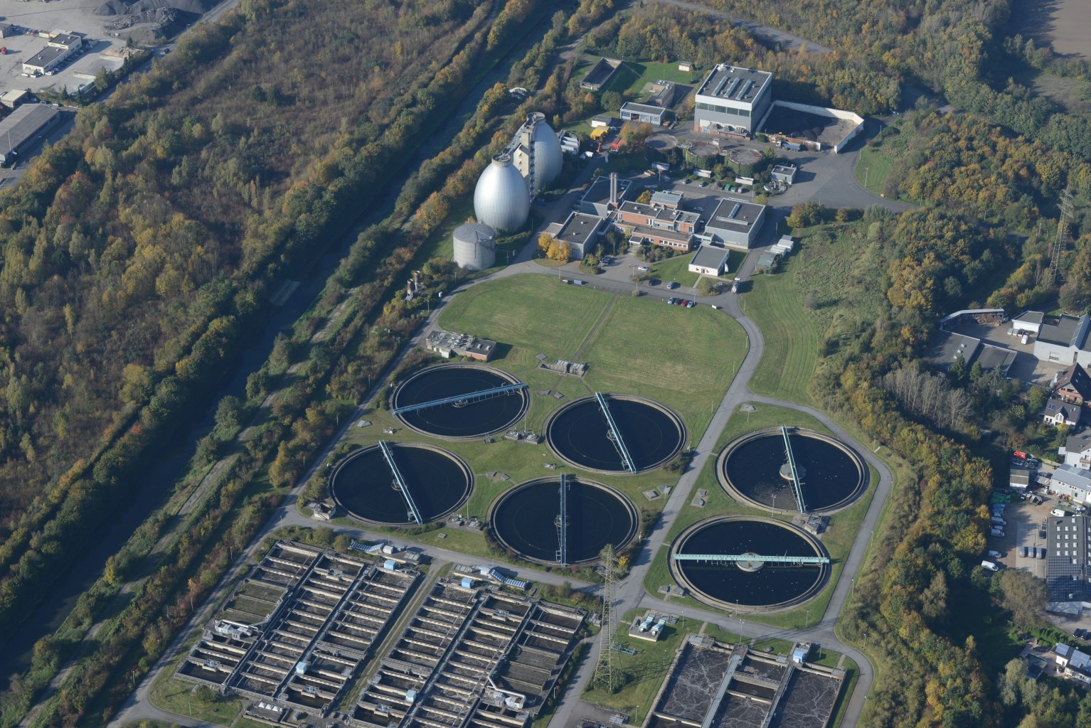 Luchtfoto van een afvalwaterzuiveringsinstallatie met meerdere zuiveringsbekkens.